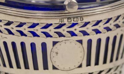 A late Victorian silver sugar basket, with bands of pierced decoration and scroll engraving, having a blue glass liner and reeded swing handle, Sheffield 1895, makers Fenton Bros, 3oz, 11cm L. - 3