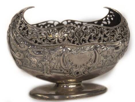 A late Victorian silver bonboniere, of oval design with pierced scroll border and embossed foliate scroll and flower head body, with blank cartouche, raised on an oval stepped foot, London 1897, makers probably Josiah Williams & Co, (mark indistinct), 6.5