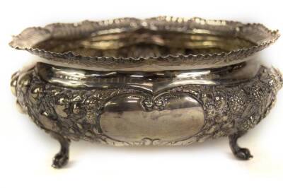 A late Victorian circular silver bowl, with 'crimped' scroll everted border and profusely decorated with repousse fruit and flower head designs, with a blank cartouche, and raised upon three pierced foliate scroll feet, Sheffield 1895, makers Atkin Bros, - 3