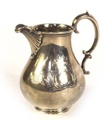 A Victorian silver milk jug, of pear shaped design with scalloped scroll spout and double scroll handle, engraved with foliate scrolls and raised upon a plain circular foot, makers Edward John & William Barnard, London 1848, 6.3oz, 12.5cm H.