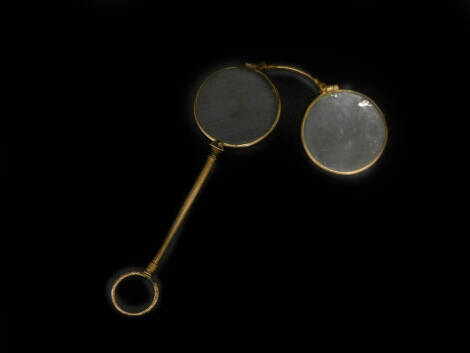 A late 19thC spring loaded lorgnette, with engine turned handle and ring end, unmarked yellow coloured metal, 14cm high.