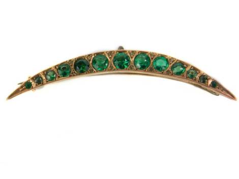 A 9ct gold crescent moon brooch, set with green stones, with a pierced and fret design border, yellow metal, marked 9ct, with later hoop pendant attachment, 2.9g all in,5.2cm wide.