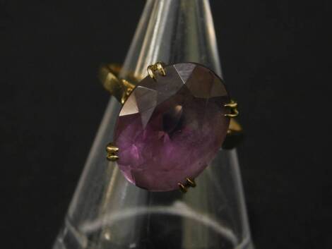 A 9ct gold amethyst dress ring, with large oval cut amethyst 16mm x 11.8mm x 7.8mm, in claw setting, with pierced basket, on plain band, maker W & G, ring size K, 4.3g all in.