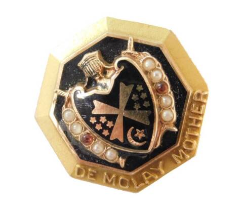 A De Molay Mother octagonal brooch, with central black enamel decoration with raised shield and sword design, set with seed pearls and ruby to each side yellow metal, marked 10K, 17mm high, 4.3g all in.