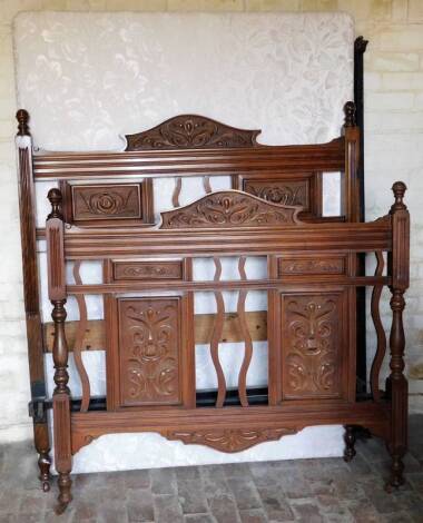 An Edwardian walnut double bed frame, comprising of a headboard carved with flowers and footboard, sprung metal Vono mattress and supports, 139cm W, and a further part bed.