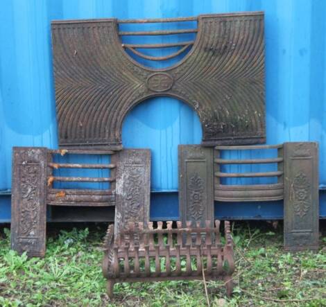 Two Edwardian cast iron fire grates, a fire back and other accessories. (a quantity)