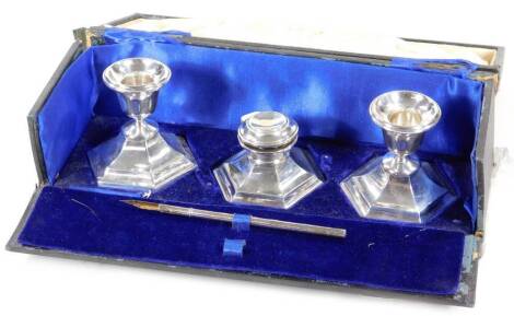 A George V silver desk set, comprising of ink stand, quill case and two candlesticks, 7cm H, in fitted case, Chester 1921, 14½oz.