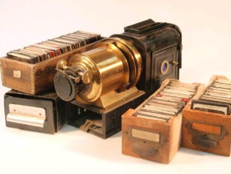 A brass and tin plate magic lantern projector and a selection of slides