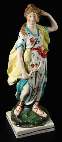 An early 19thC Staffordshire pottery figure Diana, holding her bow and taking out a arrow from her quiver, on a square base, c1800, 29cm H.