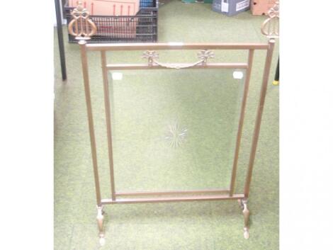 An Art Nouveau brass framed mirror fire screen