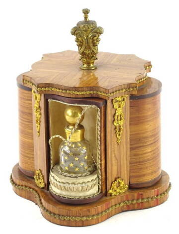 A Continental Kingwood dressing table stand, with gilt metal mounts, the revolving finial moving part cylindrical compartments, containing coloured glass scent bottles, each with gilt stars, on a shaped base, 19cm H.