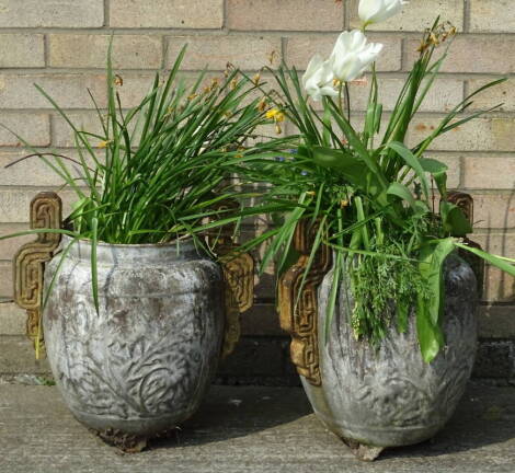 A pair of oriental style cast iron urns, each with two shaped handles and decorated with flowers etc., 41cm H.