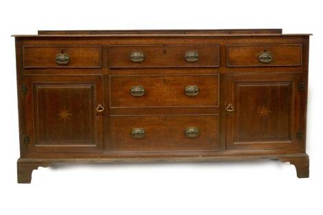 A late 18thC oak dresser base, with low level drawer frieze on a moulded top, with three frieze drawers over two dummy drawers, all with cock beading, enclosed by two fielded panel doors with parquetry star centres, moulded base with bracket feet, 86cm p