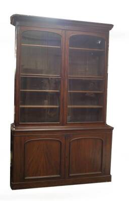 A Victorian mahogany cabinet bookcase, with moulded overhang cornice over two arch moulded and glazed doors, revealing adjustable shelves with mahogany fronts over two arch moulded panel doors, revealing two drawers over shelf and covered base on plinth, - 2