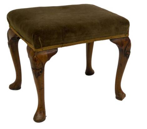 A Georgian style walnut stool, with green velvet seat and raised on four stylised carved cabriole legs with pad feet, 40cm H, 50cm W, 38cm D.