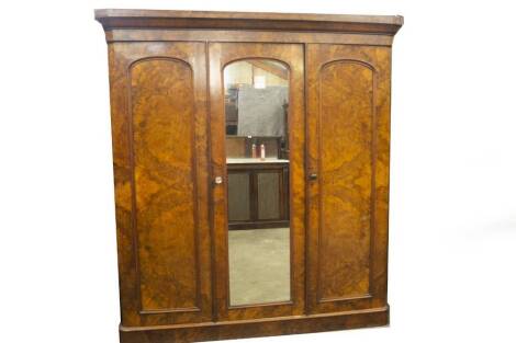 A Victorian burr and figured walnut triple wardrobe, with moulded cornice, arch moulded mirror centre door, revealing a double width arrangement of press drawers and solid drawers with integral moulded handles to the left and full length hanging with box 