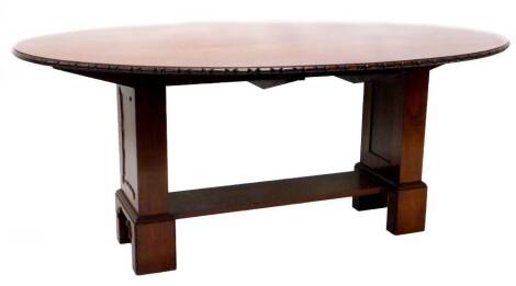 A mahogany oval dining table, with a carved moulded edge, on square section end supports and block feet, 76cm H, the top 121cm x 177cm.