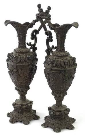 A pair of late 19thC Continental cast iron ewers, each decorated in renaissance style with masks, scrolls, flowers etc., 48cm H.