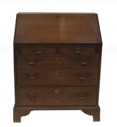 A George II oak bureau, with fall flap resting on lopers, revealing a fitted interior of drawers and pigeon holes, over two short and three long graduated drawers with brass swan neck handles and bracket feet, 96cm H, 77cm W, 50cm D.