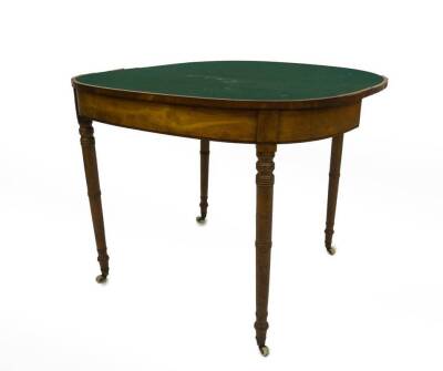 A George III satinwood card table, with rounded rectangular rosewood crossbanded folding top, frieze with ebony stringing on ringed turned taper legs with brass cup and ceramic castors, 72cm H, 90cm W, 45cm D when closed. - 2