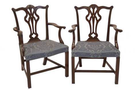 A set of six Chippendale design mahogany dining chairs, including two carvers, with pierced vase splats and overstuffed blue damask seats.