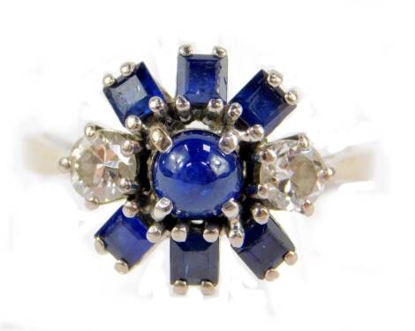 A sapphire and diamond star burst cluster ring, set with a pair of brilliant cut diamonds single cabachon and six square cut sapphires, in yellow metal and platinum, diamonds approx 0.5cts, size Q, 4.6g.