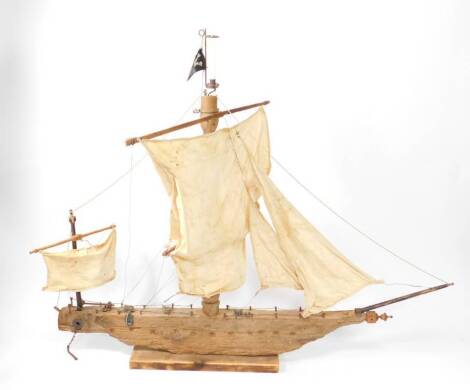 A Norfolk driftwood handmade model of a two masted pirate ship, fully rigged with sails, made from RAF/army parachute fabric, raised on a rectangular base, 193cm L.
