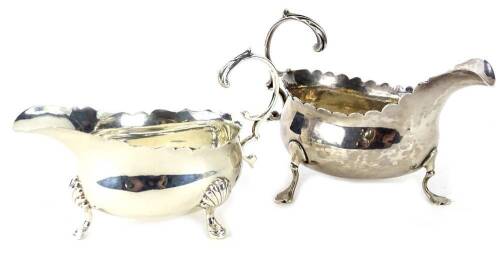 Two similar silver sauce boats, each with a wavy edge, scroll cast handle and three feet, 6½oz.