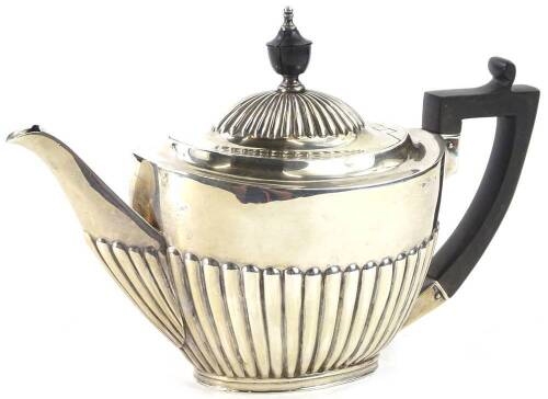 A late Victorian silver teapot, with part fluted body, ebonised knop and handle, London 1897, 14oz gross.