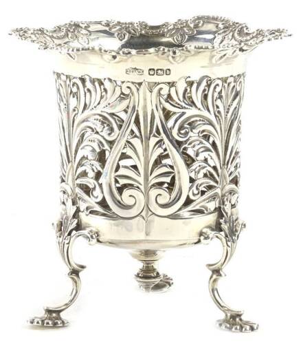 An Edwardian silver vase or basket, with a shaped rococo scroll edge, foliate pierced sides on 'C' scroll and flower head, on three 'C' scroll legs, terminating in a patera shaped foot, Sheffield 1900, lacking liner, 4¾oz, 11cm H.