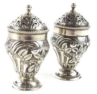 A pair of small Victorian silver salt pots, each with embossed decoration of scrolls, flowers etc., on a domed foot, London 1882, 1oz, 5cm H.