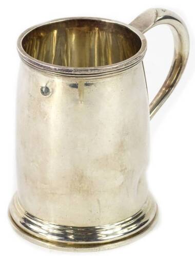 A George VI plain silver Christening mug, with reeded band, shaped handle and heart shaped thumb piece, on a tapering foot, Sheffield 1945, 8¼oz, 10cm H.