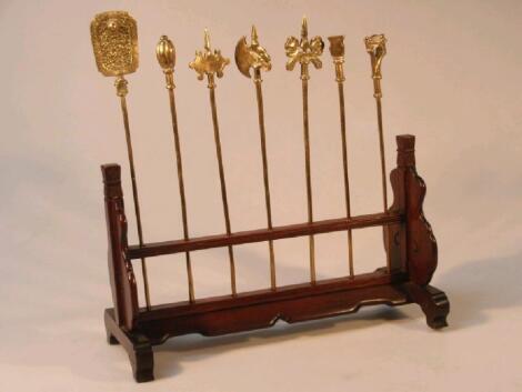 A Chinese rosewood stand housing seven brass models of war implements and standards