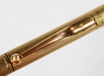 A 9ct gold propelling pencil, with engine turned body, shaped clip and plain lead, 11cm W. - 2