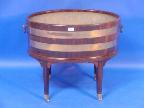 A George III mahogany oval brass bound wine cooler with two oval ring handles