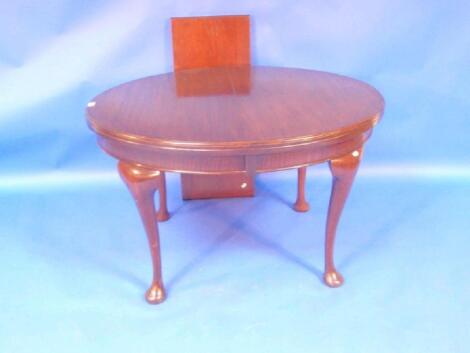 A George V mahogany extending dining table with oval moulded top on cabriole