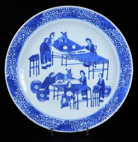 A Chinese porcelain blue and white plate, centred by scholars at work, with an outer floral border, four character Yongzheng double circle mark beneath, 29.5cm Dia.