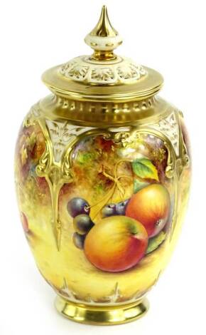 A Royal Worcester porcelain vase and cover, decorated with fruit by Paul English, the pierced lid with a tapering finial, the base decorated with fruit within Arab style gilt arches, printed mark in black to underside, and numbered 169B, in presentation b