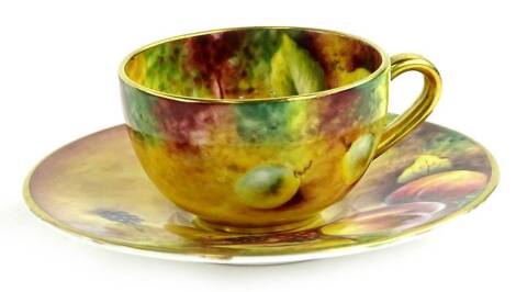 A Royal Worcester porcelain cup and saucer, painted with fruit by T Knott, printed mark in black to underside.