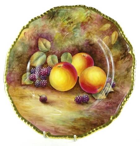 A Royal Worcester porcelain plate, decorated with fruit by J Skerrett, within gilt borders, printed marks in black to underside, 27cm dia.