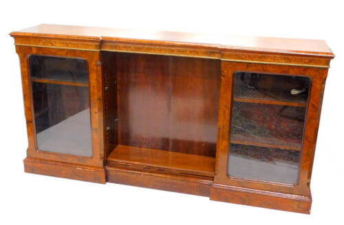 A Victorian walnut and marquetry inverted break front bookcase, the top with a moulded edge above a frieze decorated with ribbons, foliate scrolls etc., above two glazed doors, flanking a central open shelved area on plinth base, 103cm H, 199cm W. Provena