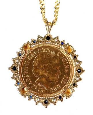 An Elizabeth II gold half sovereign pendant, in fancy mount set with blue and white stones, attached to a slender link chain, 9g all in. - 2