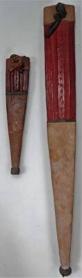 A 20thC African tribal knife and scabbard, probably Nigerian, with metal shaped end and turned handle, 56cm W, and another similar, but smaller. (2) - 4
