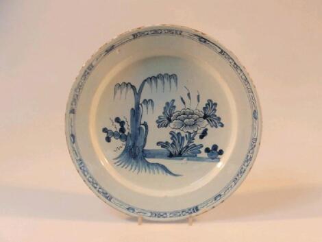 An 18thC Dutch Delft saucer dish with floral central field