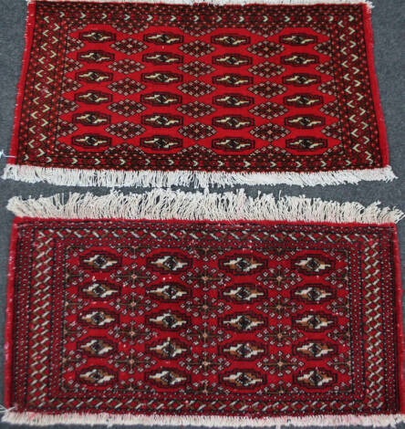 A matched pair of Turkoman rugs, in red geometric pattern, 89cm x 49cm. (2)