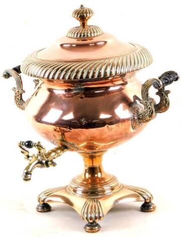 An early 20thC copper and brass samovar, of bellied circular form, flanked by scroll carrying handles and surmounted by a compressed lid with shaped handle, with a tap front, on an inverted platform base, terminating in compressed bun feet, 49cm H.