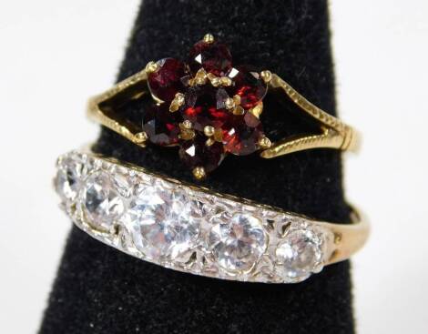 Two silver dress rings, to include one floral cluster set with red paste stones in claw setting, ring size O and another half hoop dress ring, set with five round cut CZ stones, in silver coloured ring head on a gold coloured silver band, ring size T, 4.2