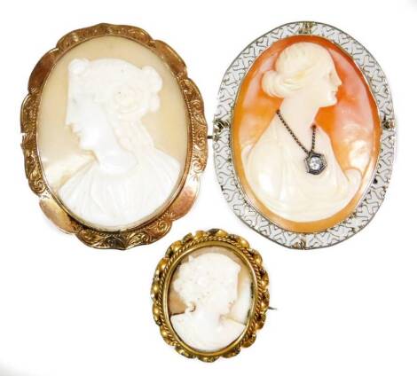 Three cameo brooches, to include an oval shell cameo, depicting lady facing sinister, in a yellow metal frame, unmarked, 5cm x 4cm, a silver plated framed cameo brooch set with cz stone necklace, a shell cameo with wirework frame, 5cm x 4cm and a smaller 