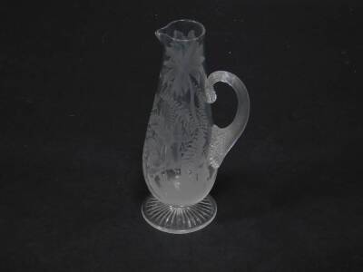 A late 19thC Stourbridge glass jug, of baluster form with a fluted handle, engraved with hummingbirds and trees, 29cm H.