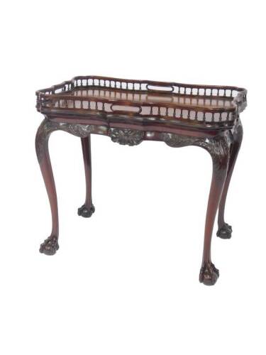 A George III serpentine mahogany silver table, with a galleried top, over a foliate carved apron and leaf carved cabriole legs on ball and claw feet, 69cm H, 76cm W, 50cm D.